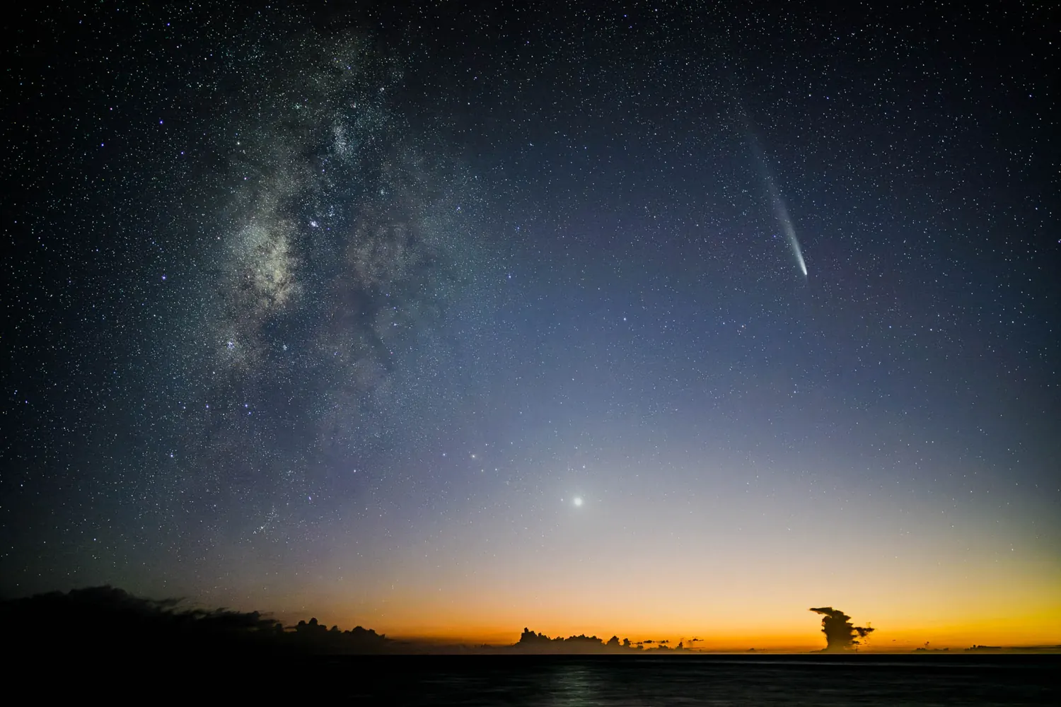 Comet and Milky Way over the sea